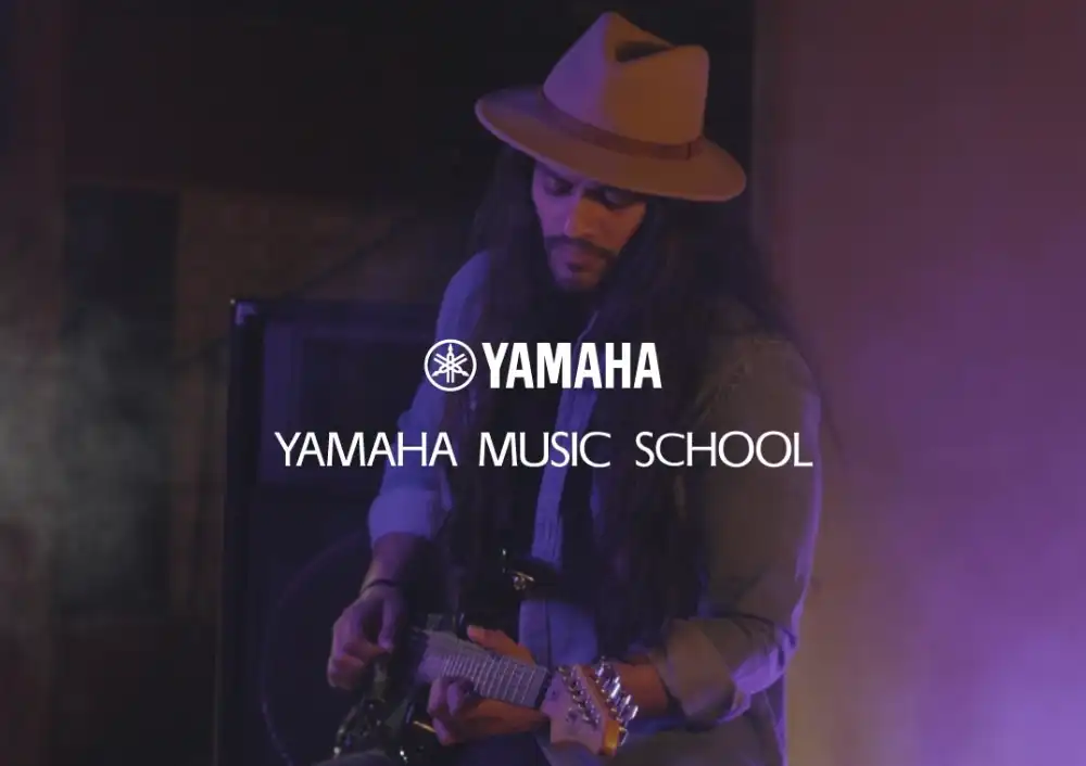 Musician playing guitar at YAMAHA Music School, promoted by Adawliah in partnership with an ad company and social media agency in Riyadh.